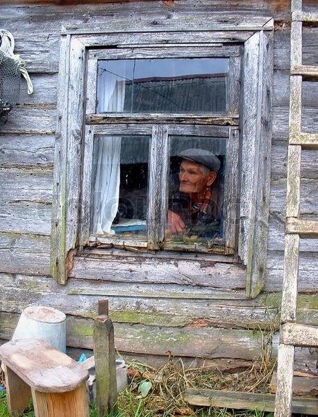 1637007-the-old-man-in-the-window-of-an-old-house.jpg