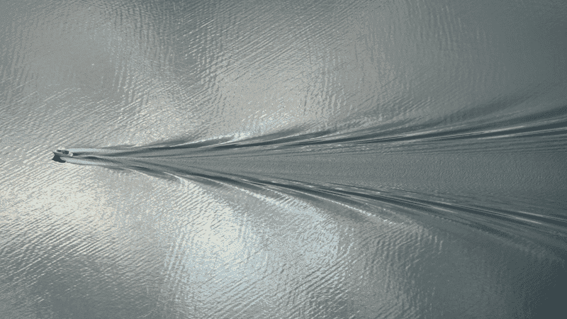 A-boat-moving-across-the-surface-of-water-producing-a-Kelvin-wake-pattern.png