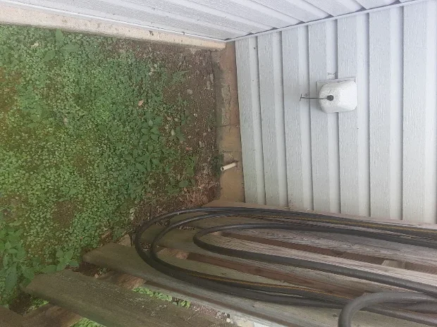 zoomed out view of drainage pipe in backyard.webp